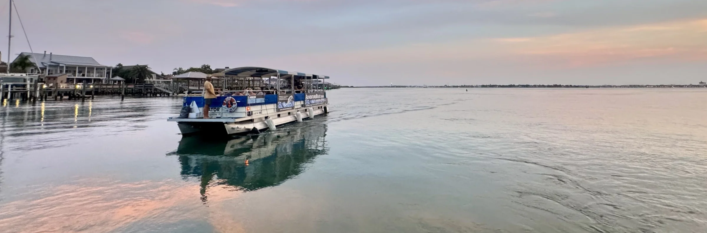 Gator pontoon boat cruising the St. Augustine waterfront in the evening